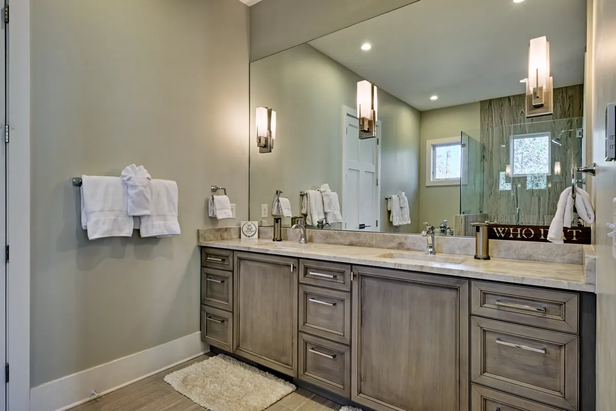 A bright, spa-inspired bathroom with a double sink vanity, expansive mirror, and elegant lighting fixtures, evoking luxury and serenity for daily self-care rituals.